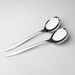 Two silver spoons on a light gray background