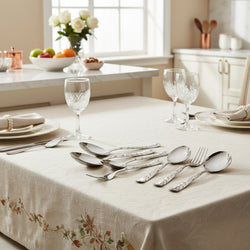 Set of silver spoons and fork with decorative handles on a gray background